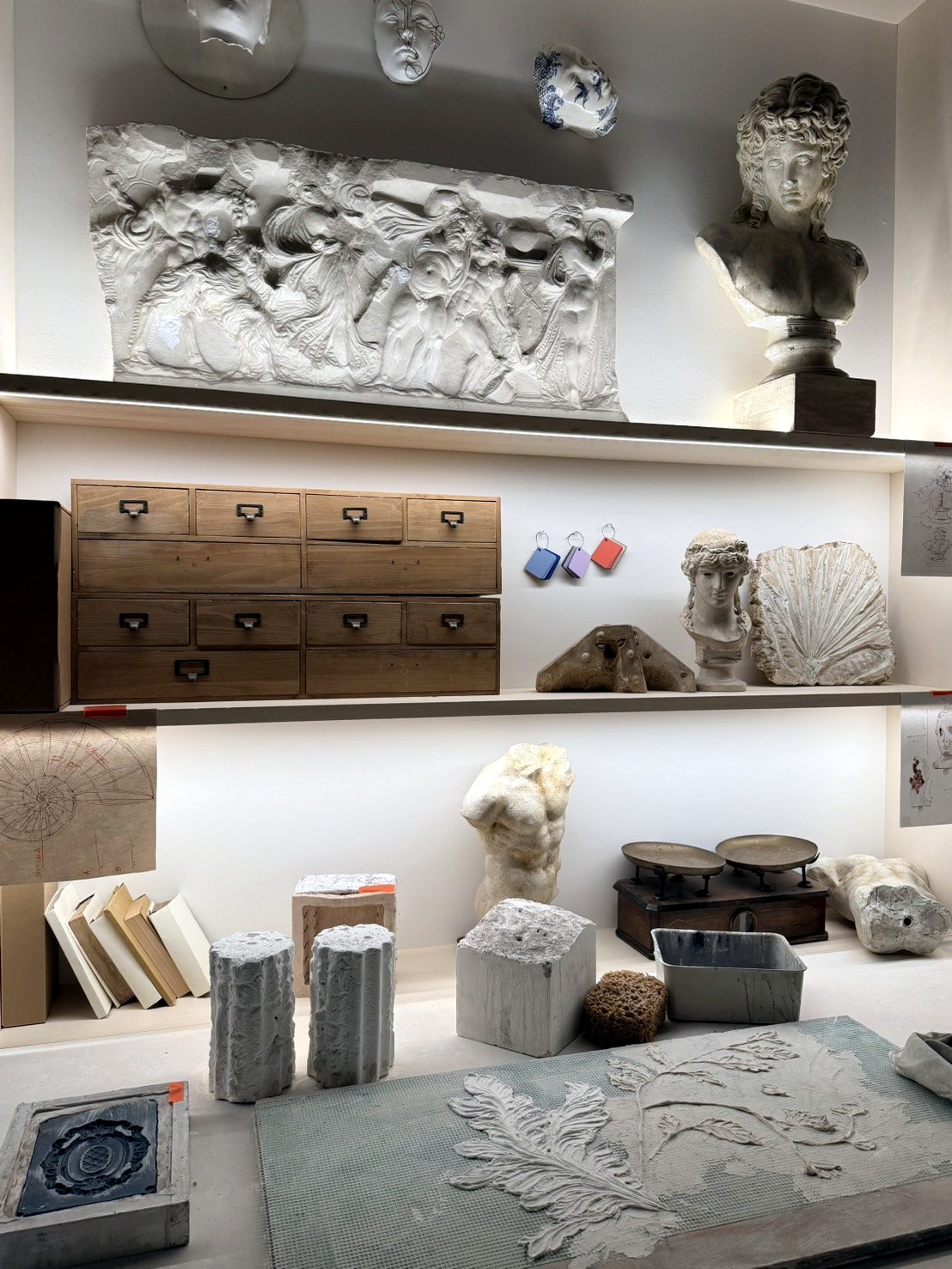 Plaster relief, bust and wooden drawers in a casting workshop